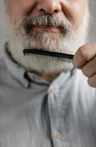 A guy combing his beard
