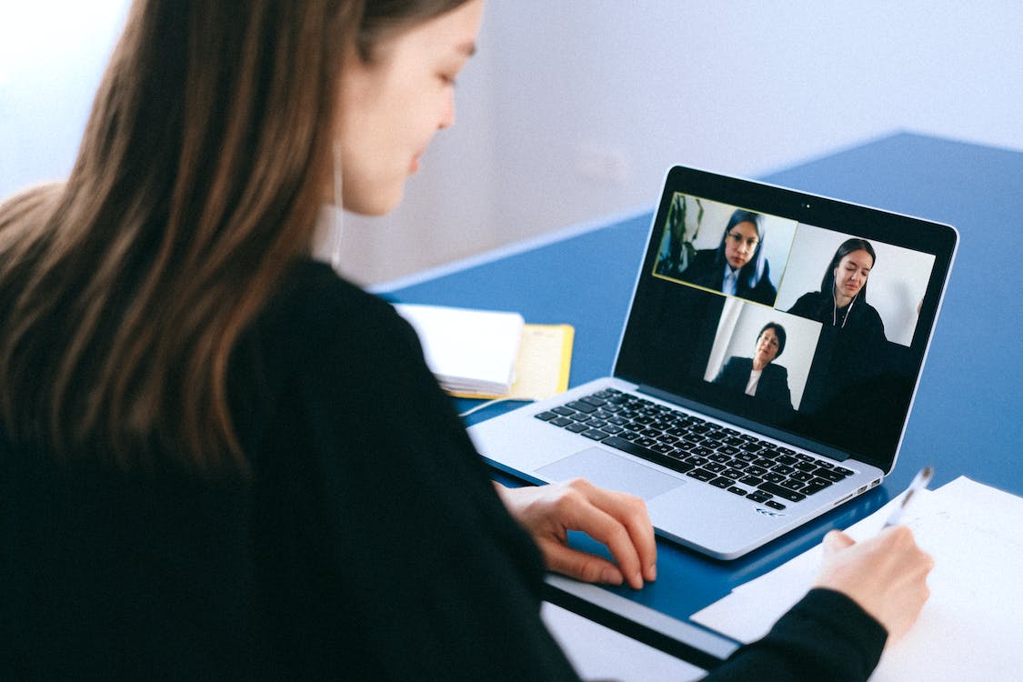 A woman on a video call with three other people